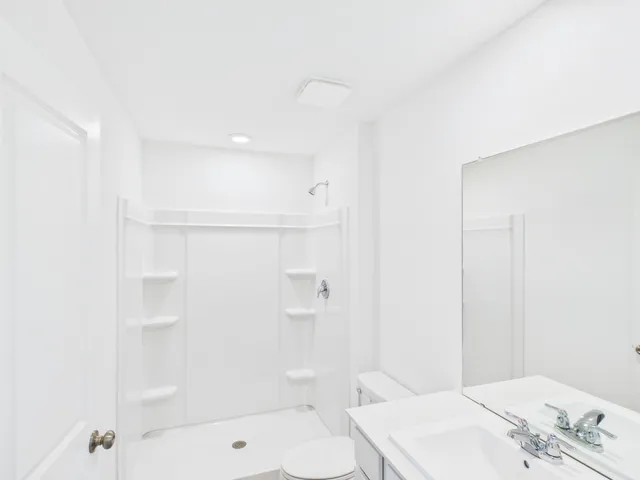 a bathroom with a bathtub shower sink vanity and toilet