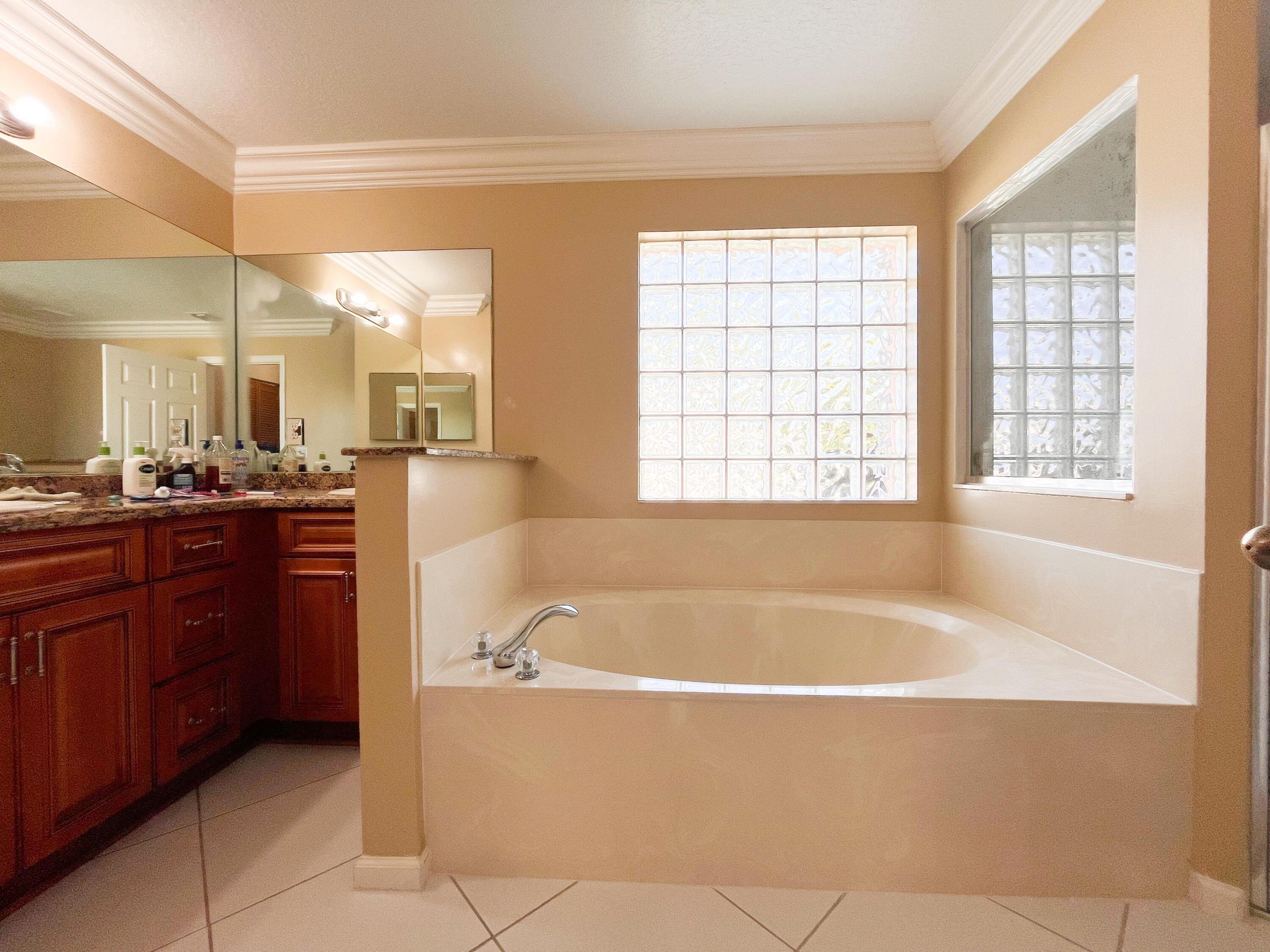 1305 Monteray Way Greenacres, FL 33413 - Photo 19 of 29 a spacious bathroom with a bathtub and a sink