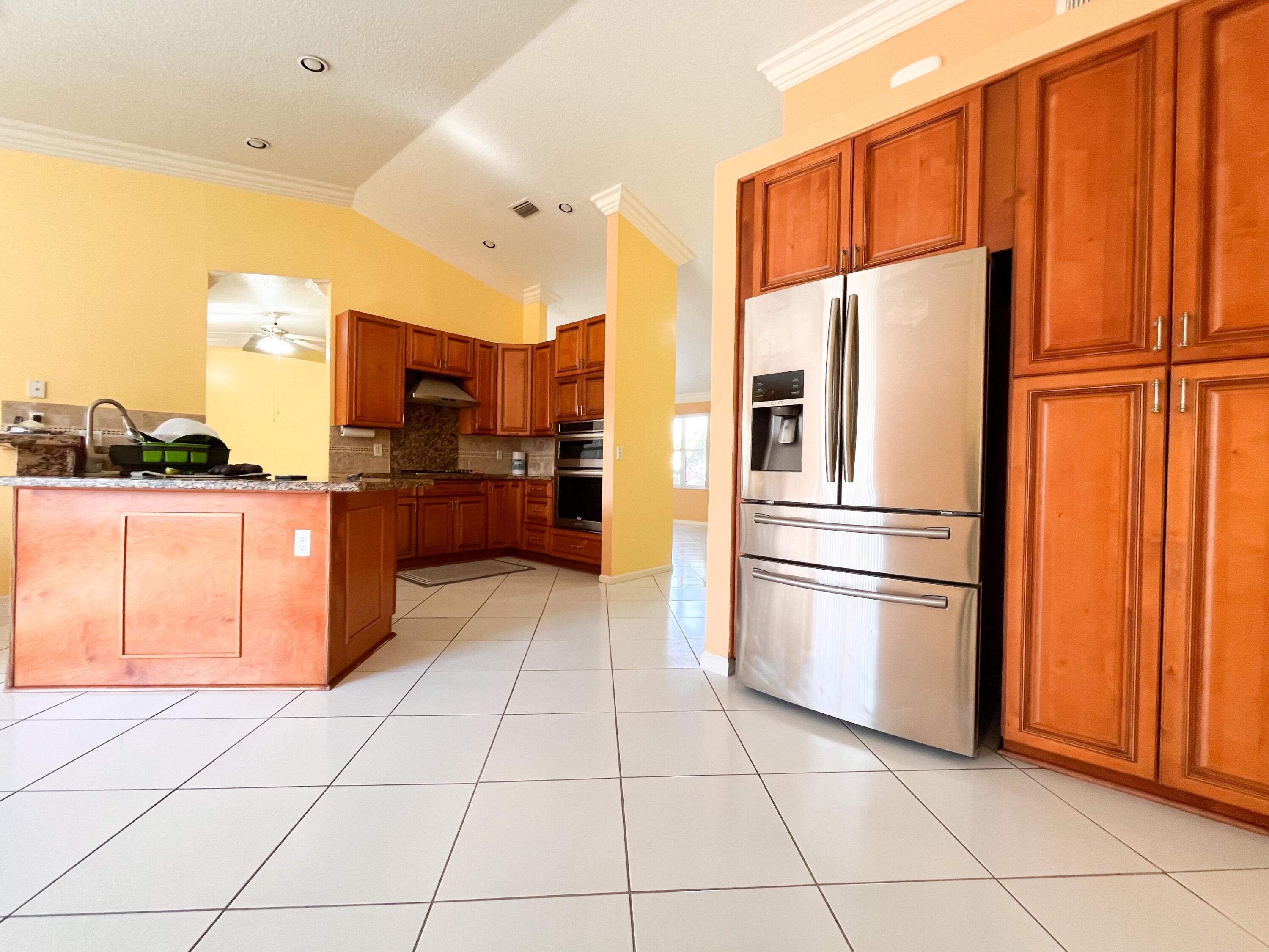 1305 Monteray Way Greenacres, FL 33413 - Photo 3 of 29 a kitchen with stainless steel appliances granite countertop a refrigerator and a sink