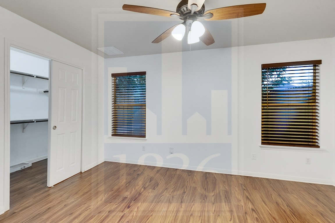 4622 Credo Lane, Unit 167 Austin, TX 78725 - Photo 11 of 25 an empty room with wooden floor fan and windows