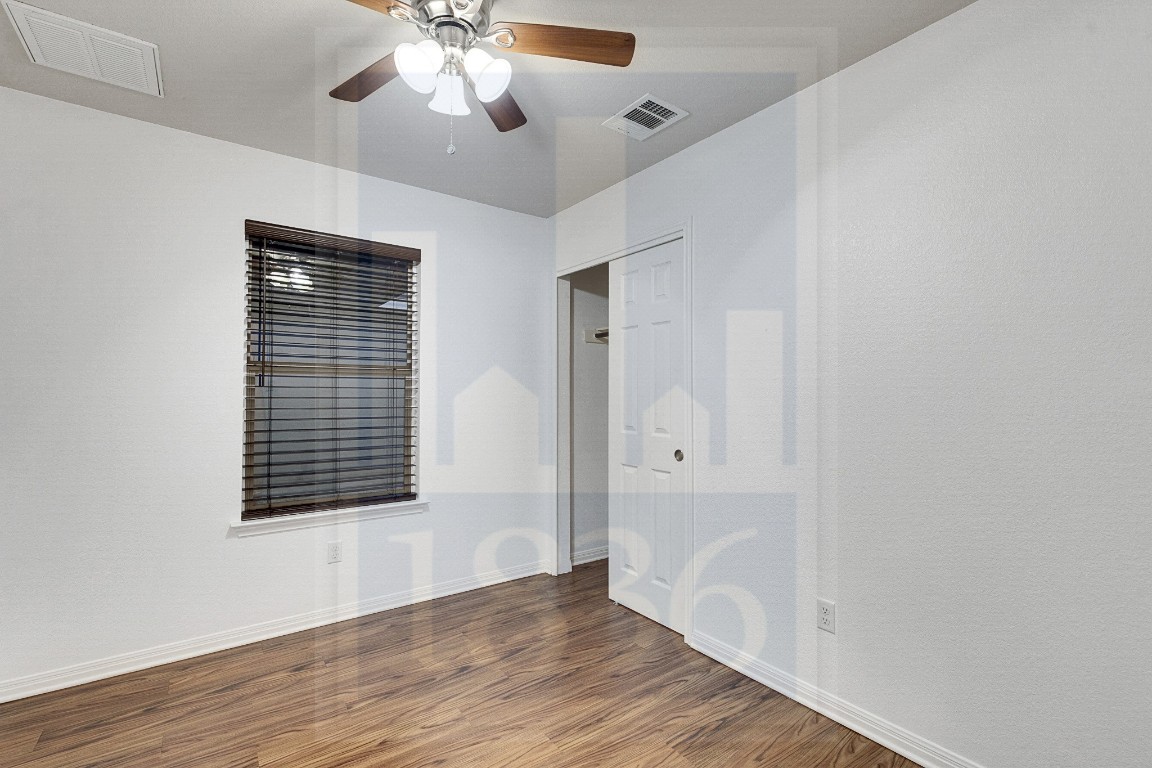 4622 Credo Lane, Unit 167 Austin, TX 78725 - Photo 13 of 25 wooden floor in an empty room with a window