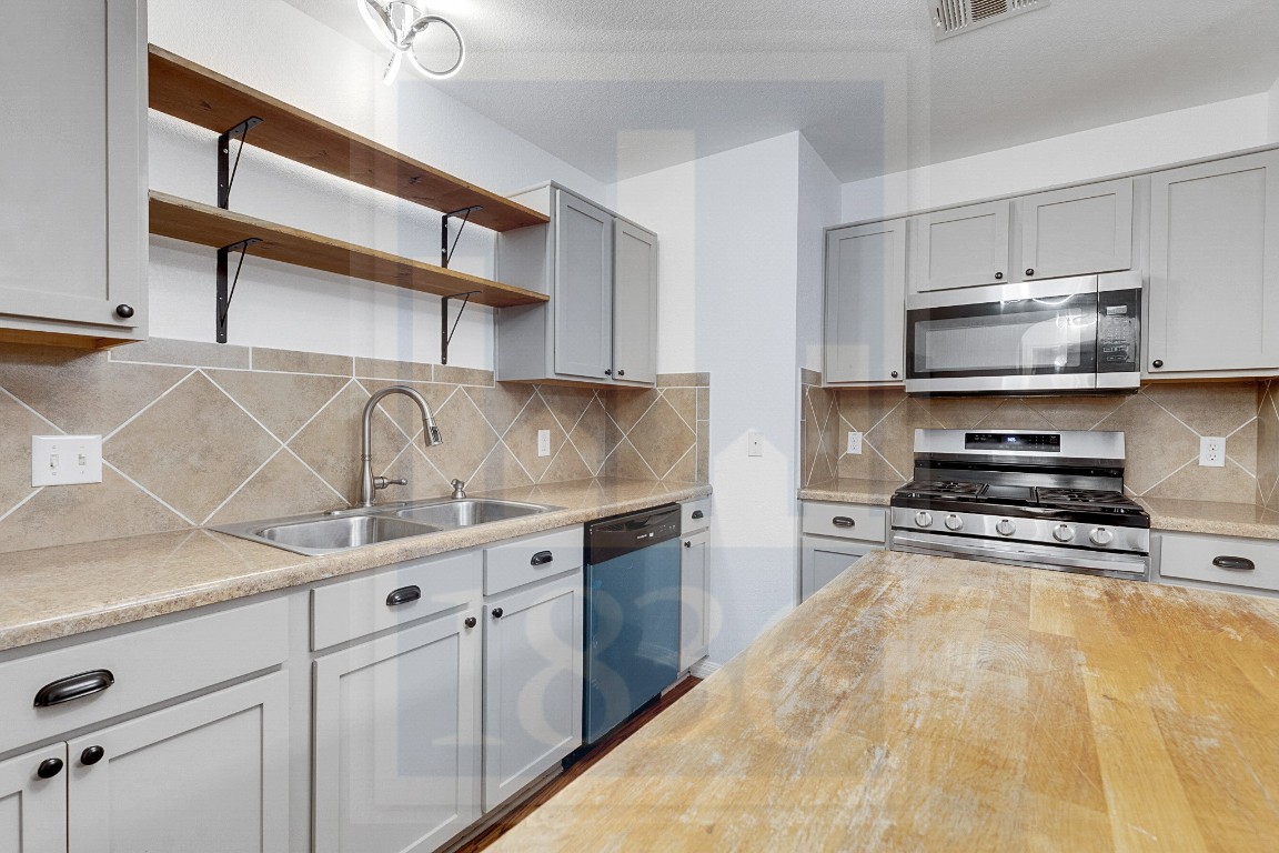 4622 Credo Lane, Unit 167 Austin, TX 78725 - Photo 6 of 25 a kitchen with stainless steel appliances granite countertop a sink stove and cabinets