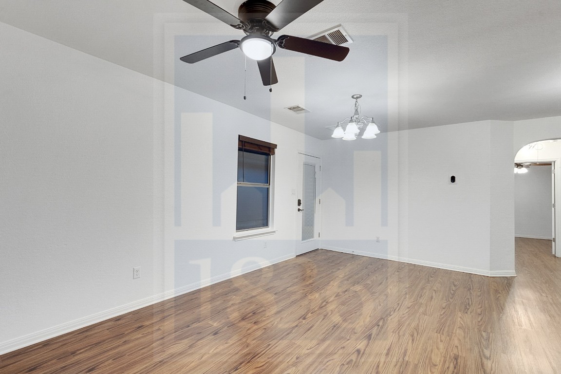 4622 Credo Lane, Unit 167 Austin, TX 78725 - Photo 9 of 25 a view of an empty room with wooden floor and a ceiling fan