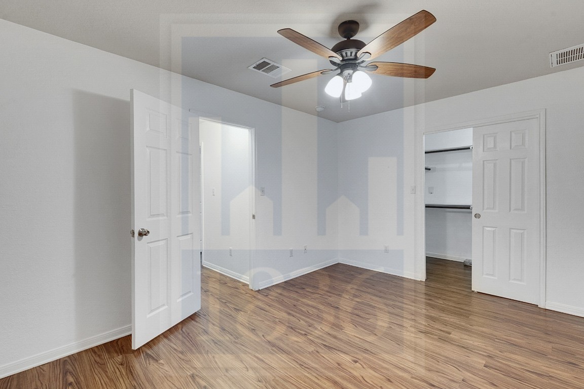 4622 Credo Lane, Unit 167 Austin, TX 78725 - Photo 10 of 25 an empty room with wooden floor and ceiling fan