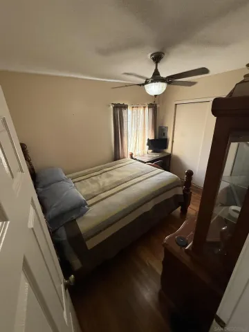 a bedroom with a bed wooden floor and window