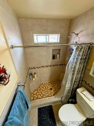 a bathroom with a toilet and a shower
