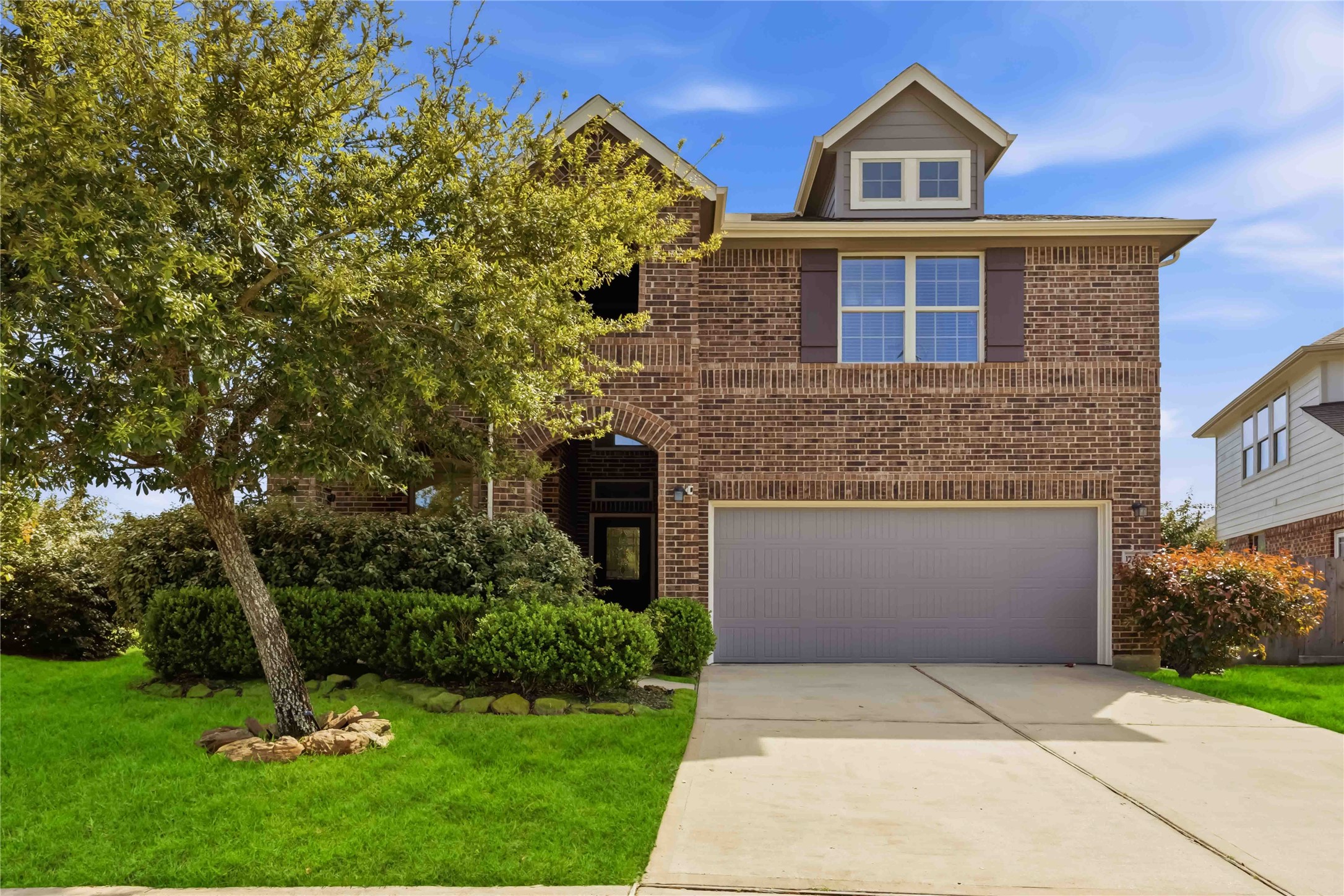 17206 Upper Ridge Lane Humble, TX 77346 - Photo 1 of 33 Front Exterior – Two-story brick exterior with a welcoming arched entryway, mature landscaping, and a well-maintained lawn offering great curb appeal.