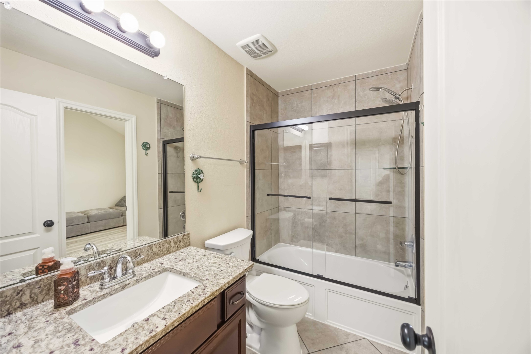 17206 Upper Ridge Lane Humble, TX 77346 - Photo 18 of 33 Secondary Bathroom – Granite counter vanity, enclosed and tiled tub/shower combo, and modern fixtures.