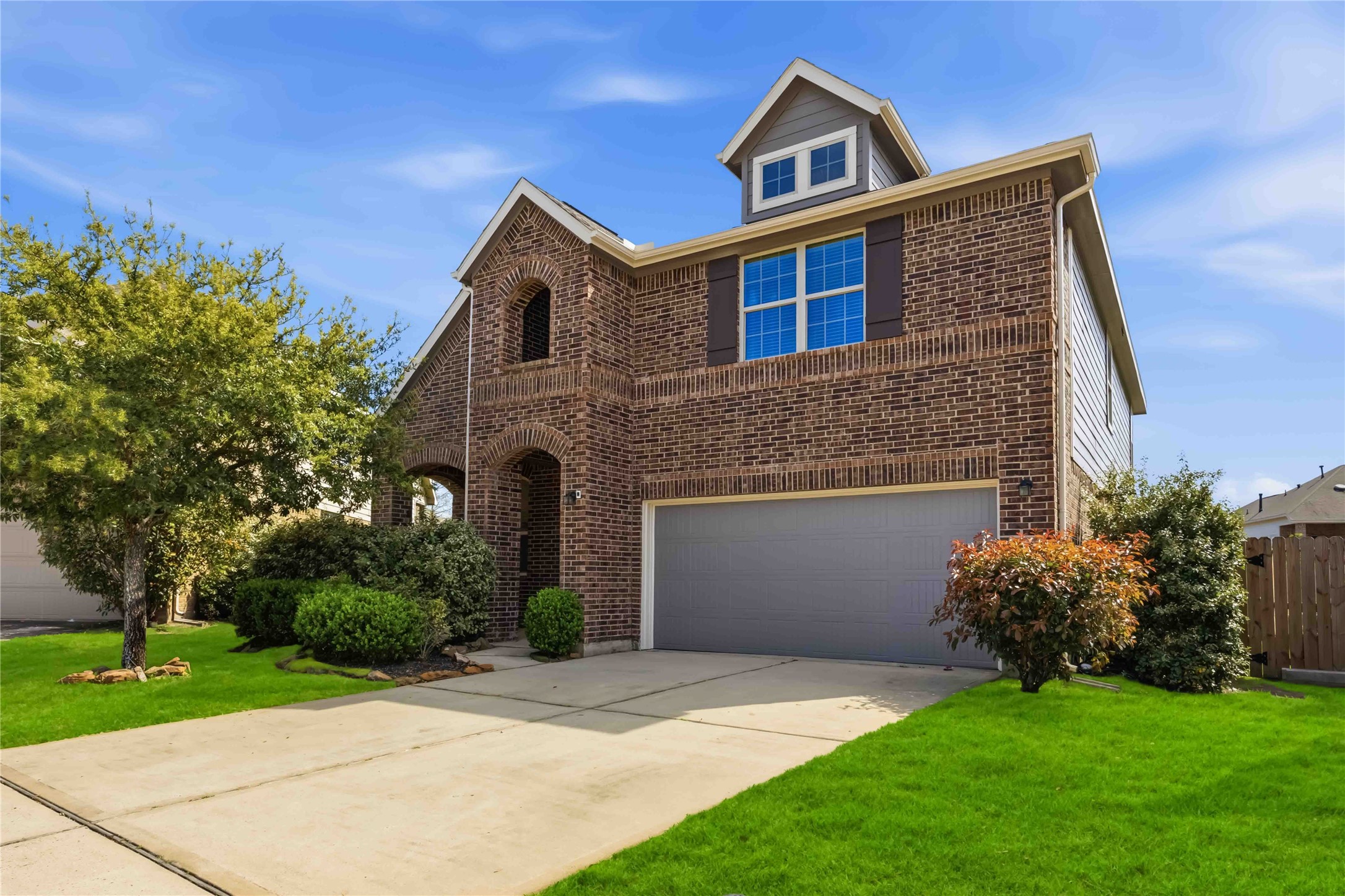 17206 Upper Ridge Lane Humble, TX 77346 - Photo 2 of 33 Front Exterior (Angle View) – Angled view highlights the home’s classic brick façade, covered entry, and spacious driveway leading to a two-car garage.