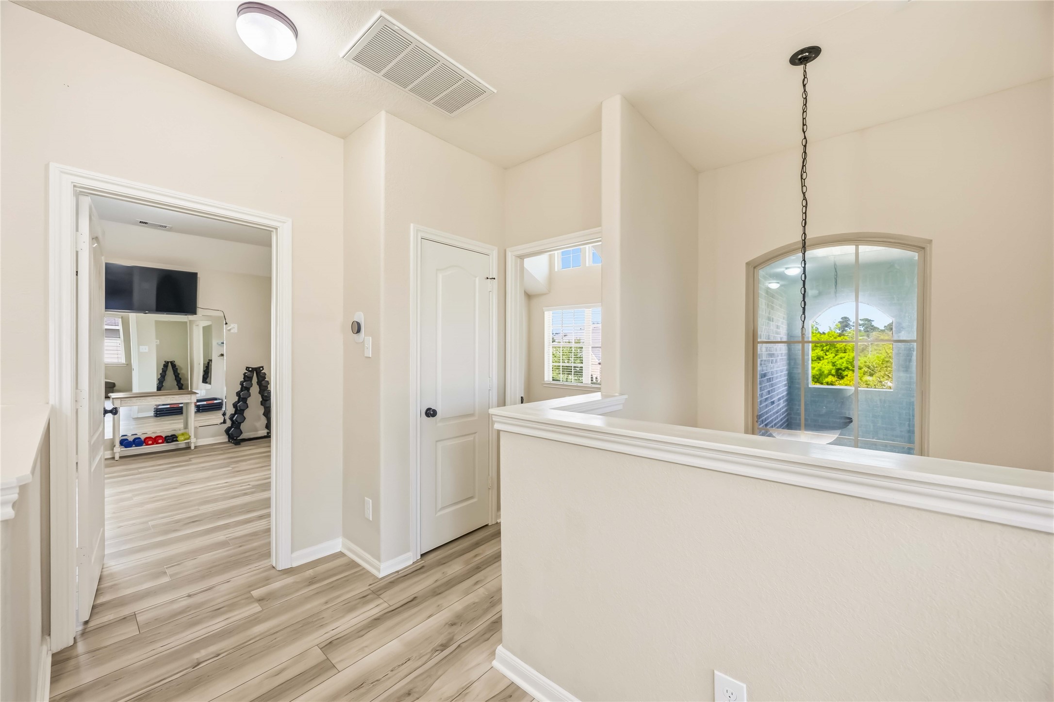 17206 Upper Ridge Lane Humble, TX 77346 - Photo 23 of 33 Upstairs Landing / Hallway – Open landing area with half wall overlooking below, offering a bright transition space between rooms.