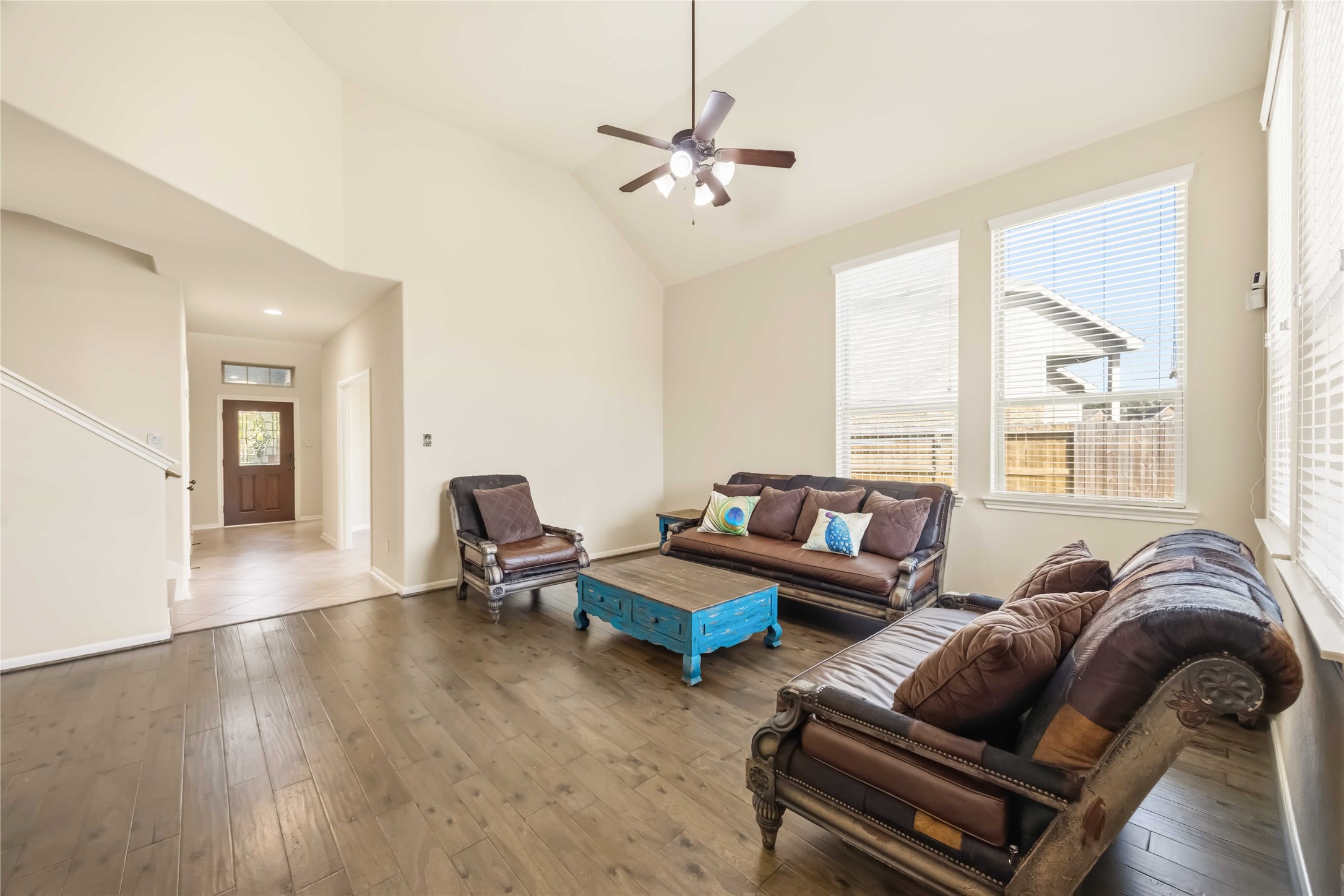 17206 Upper Ridge Lane Humble, TX 77346 - Photo 6 of 33 Living Room (Reverse View) – Comfortable seating area with expansive windows and a ceiling fan, offering a light-filled setting with backyard views.