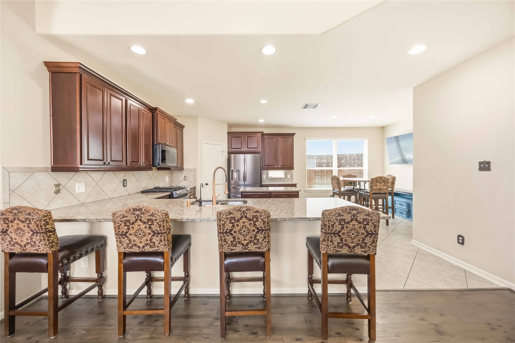17206 Upper Ridge Lane Humble, TX 77346 - Photo 7 of 33 Kitchen & Breakfast Bar – Open kitchen with granite countertops, ample cabinetry, and a large breakfast bar with seating.