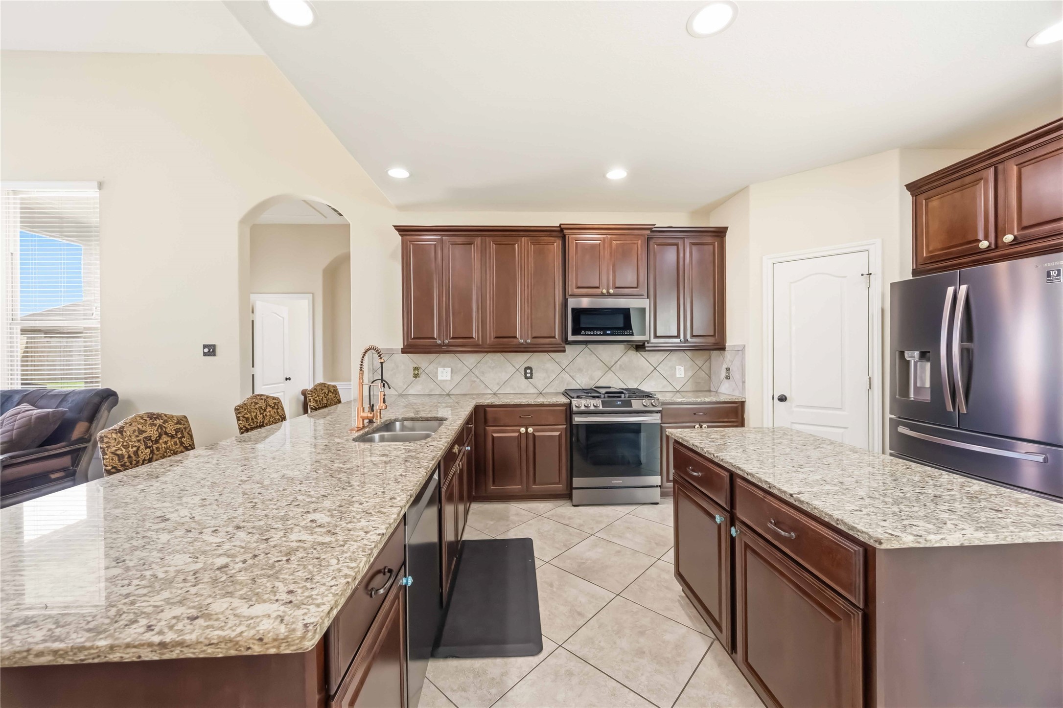 17206 Upper Ridge Lane Humble, TX 77346 - Photo 8 of 33 Kitchen – Well-appointed kitchen featuring new Samsung appliances, rich wood cabinetry, tile backsplash, and generous counter space for meal prep.