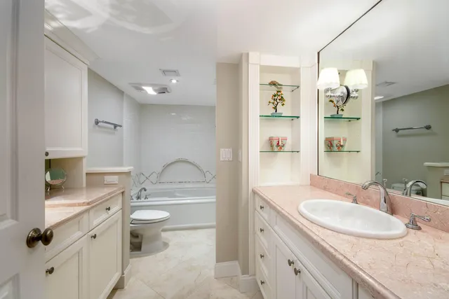 a bathroom with a granite countertop sink toilet and shower