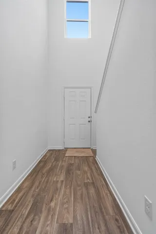 a view of a room with wooden floor and white walls
