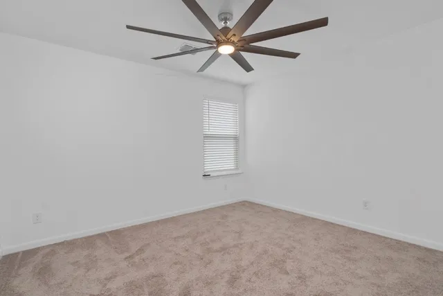 an empty room with a window and a fan