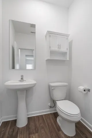 a bathroom with a toilet a sink and mirror