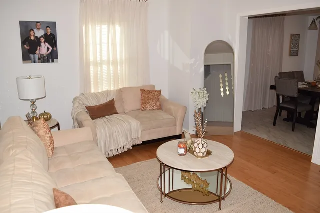 a living room with furniture and a wooden floor