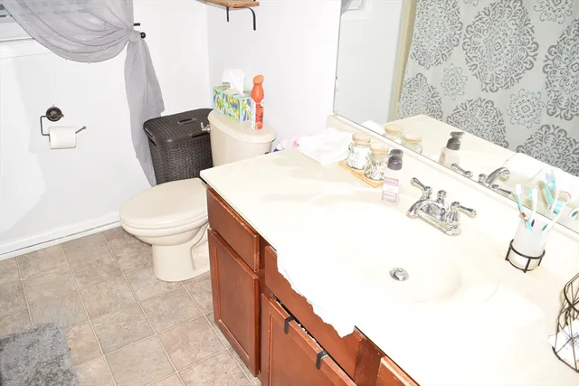 a bathroom with a sink a toilet and shower curtain