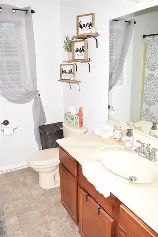 a bathroom with a sink vanity mirror and toilet