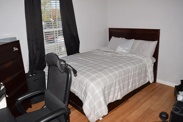 a bedroom with a bed and wooden floor