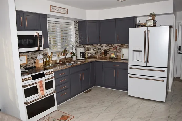 a kitchen with stainless steel appliances a refrigerator stove and sink