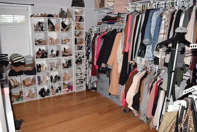 a view of walk in closet with clothes and shoes