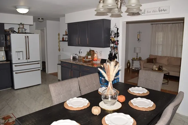 a kitchen with stainless steel appliances granite countertop a table chairs stove and refrigerator