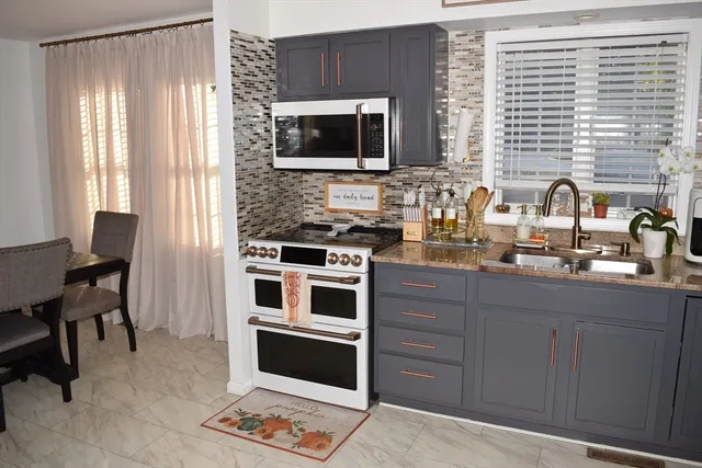 a kitchen with stainless steel appliances a stove sink and microwave