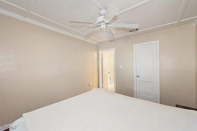 a bedroom with a bed and a chandelier fan