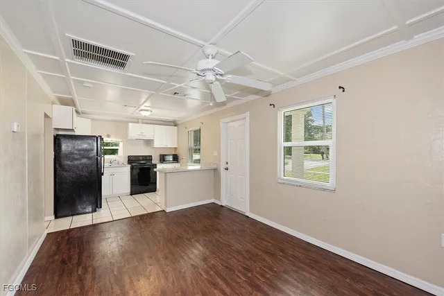 a kitchen with granite countertop a refrigerator and wooden floor