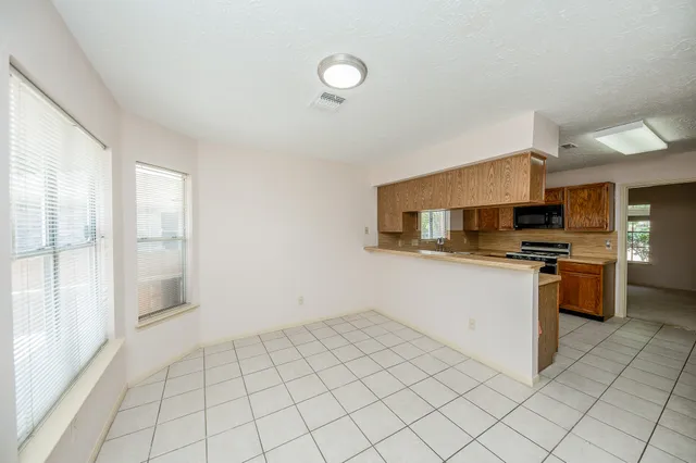 a kitchen with granite countertop a sink cabinets and stainless steel appliances