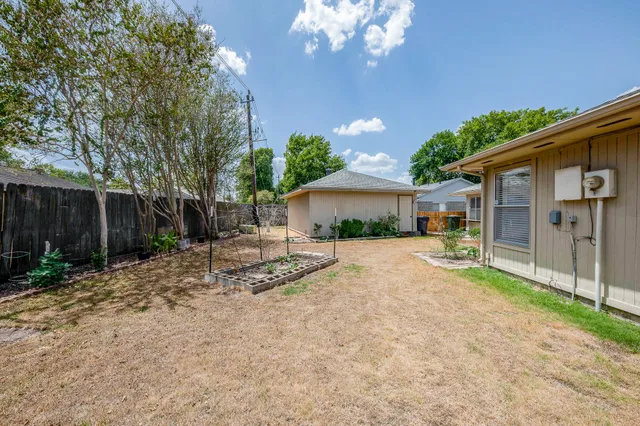a view of a house with backyard and a tree