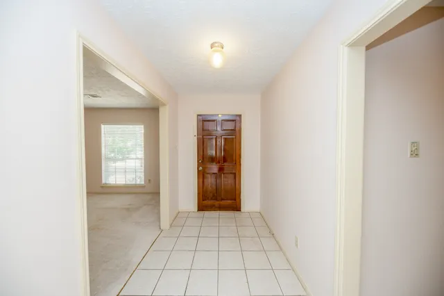 a view of an empty room with closet and mirror