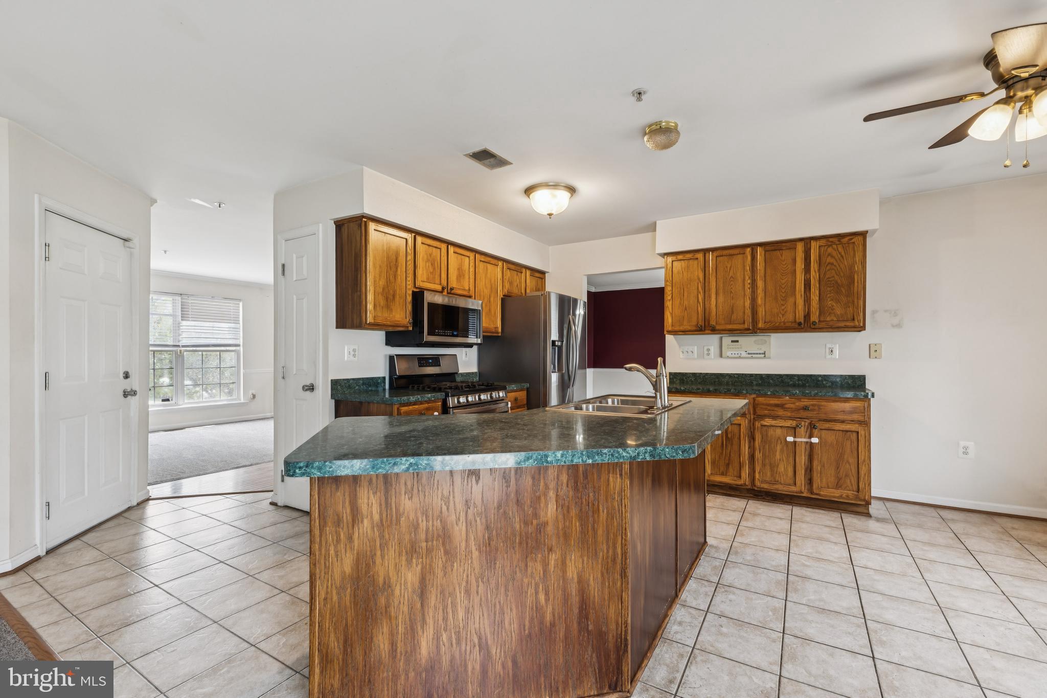 8305 Joan Place Clinton, MD 20735 - Photo 15 of 40 a large kitchen with granite countertop a large counter top space a sink a window and stainless steel appliances