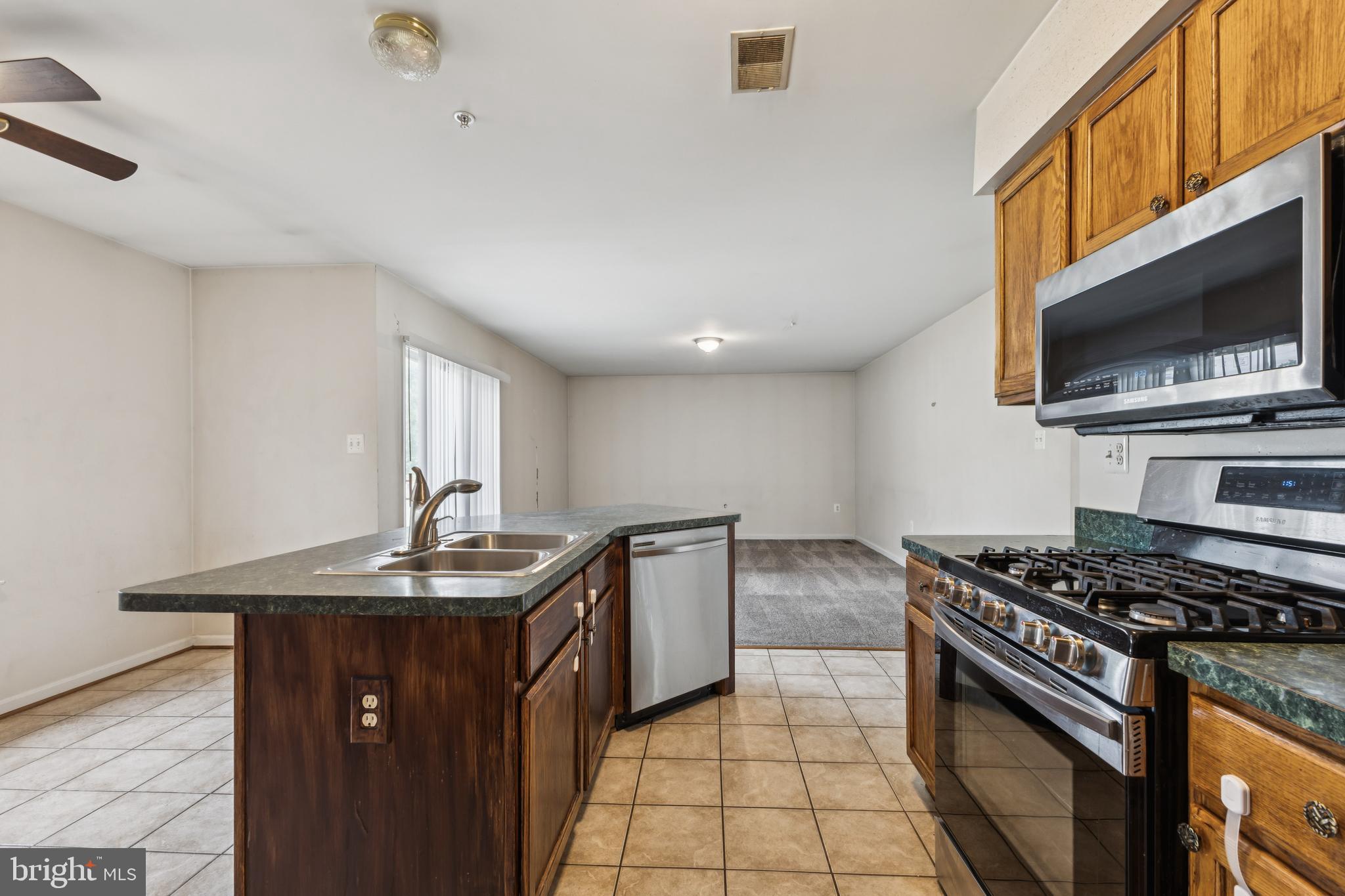 8305 Joan Place Clinton, MD 20735 - Photo 16 of 40 a kitchen with stainless steel appliances granite countertop a sink stove oven and cabinets