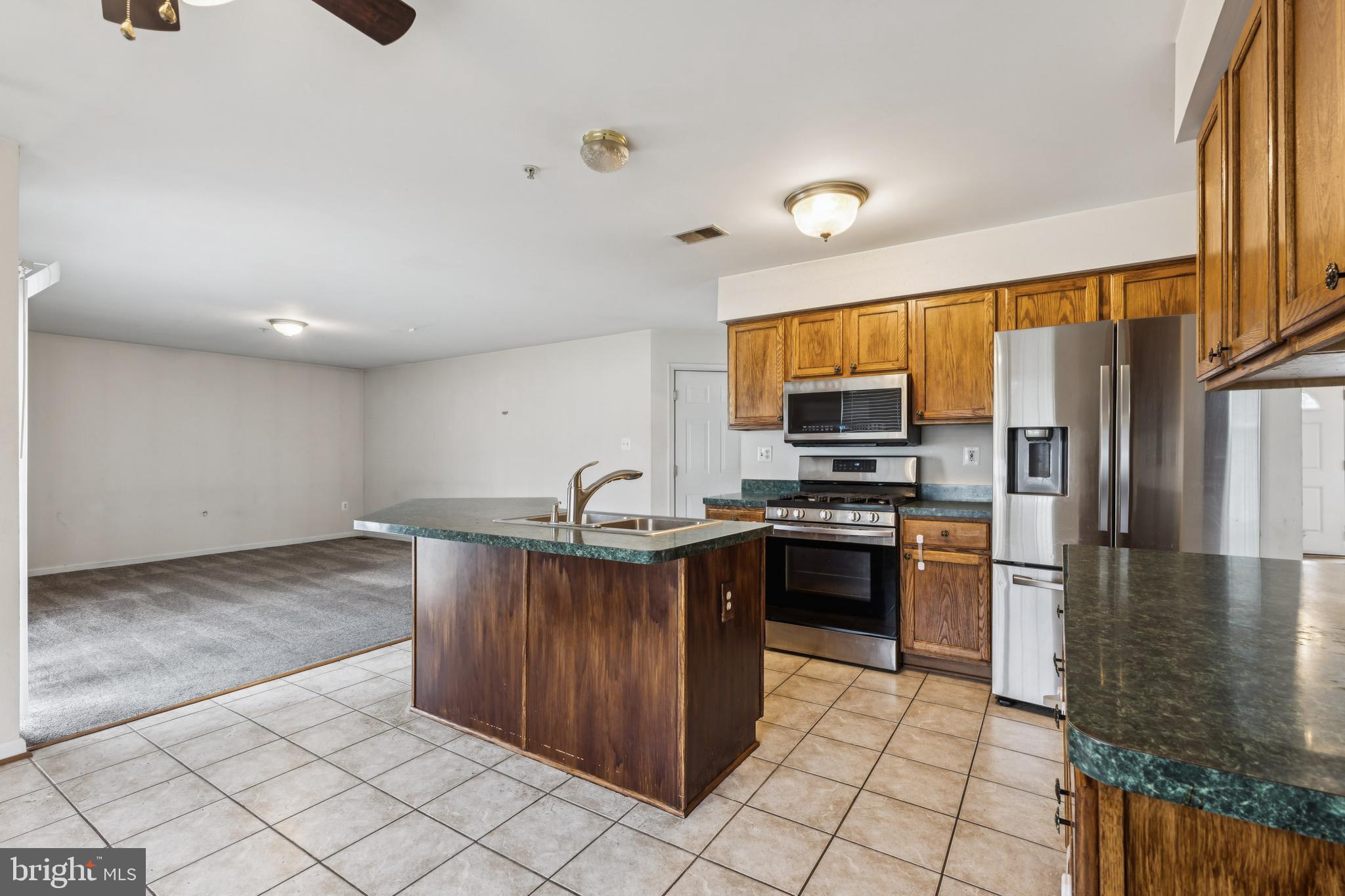 8305 Joan Place Clinton, MD 20735 - Photo 17 of 40 a kitchen with stainless steel appliances granite countertop a refrigerator and a stove top oven