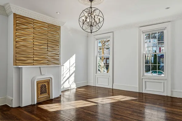 a view of a livingroom with a chandelier wooden floor and a chandelier