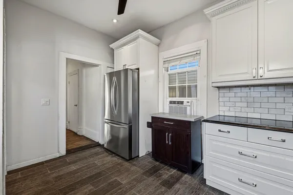a kitchen with granite countertop a refrigerator and a sink