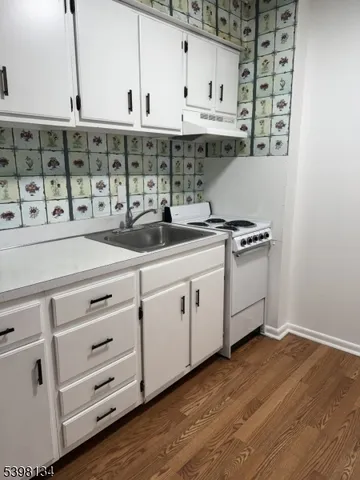 a kitchen with stainless steel appliances granite countertop a sink a stove and a wooden floors