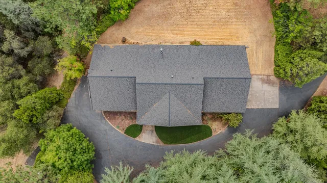 an aerial view of a house with yard and trees