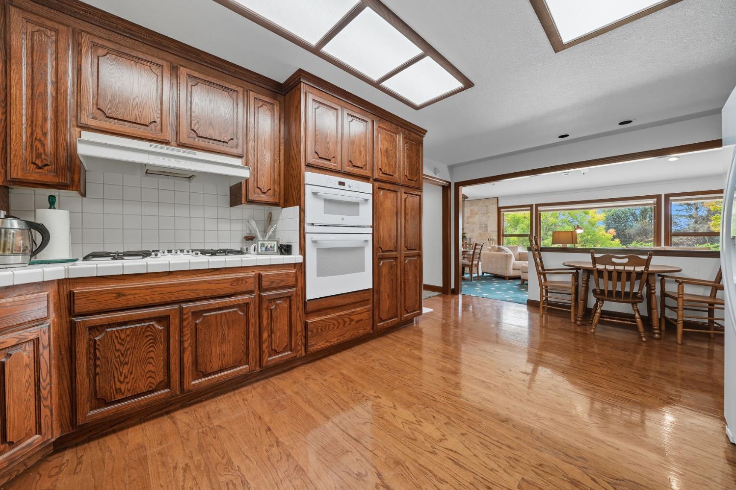 19491 East Clinton Road Jackson, CA 95642 - Photo 30 of 72 a kitchen with stainless steel appliances granite countertop a stove top oven a sink dishwasher and cabinets with wooden floor