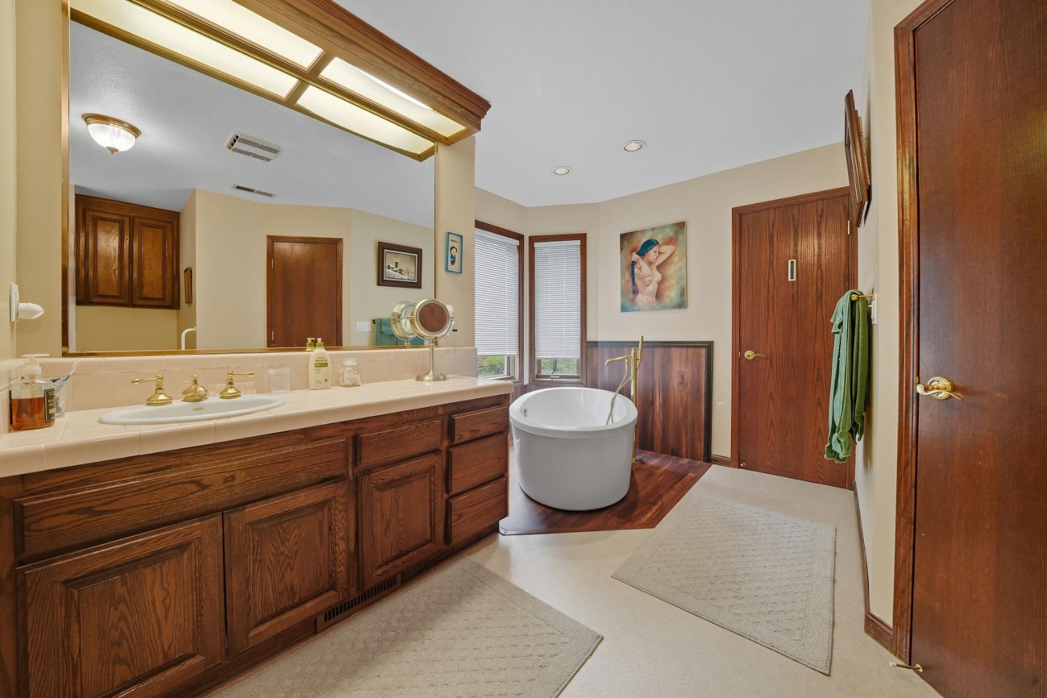 19491 East Clinton Road Jackson, CA 95642 - Photo 39 of 72 a spacious bathroom with a granite countertop sink and a mirror