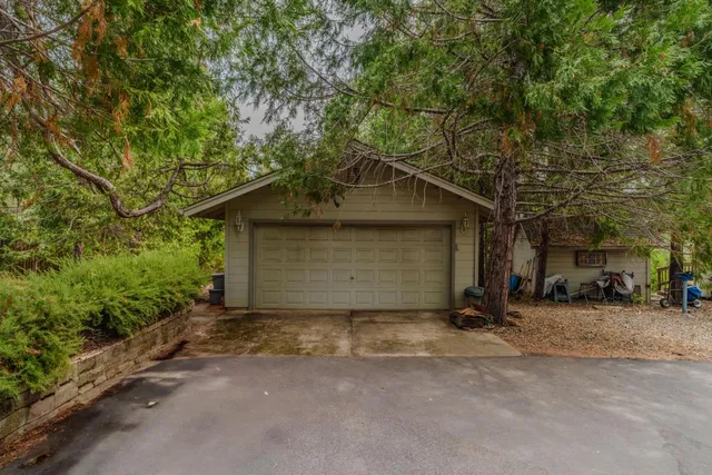 an aerial view of a house with a yard and large trees