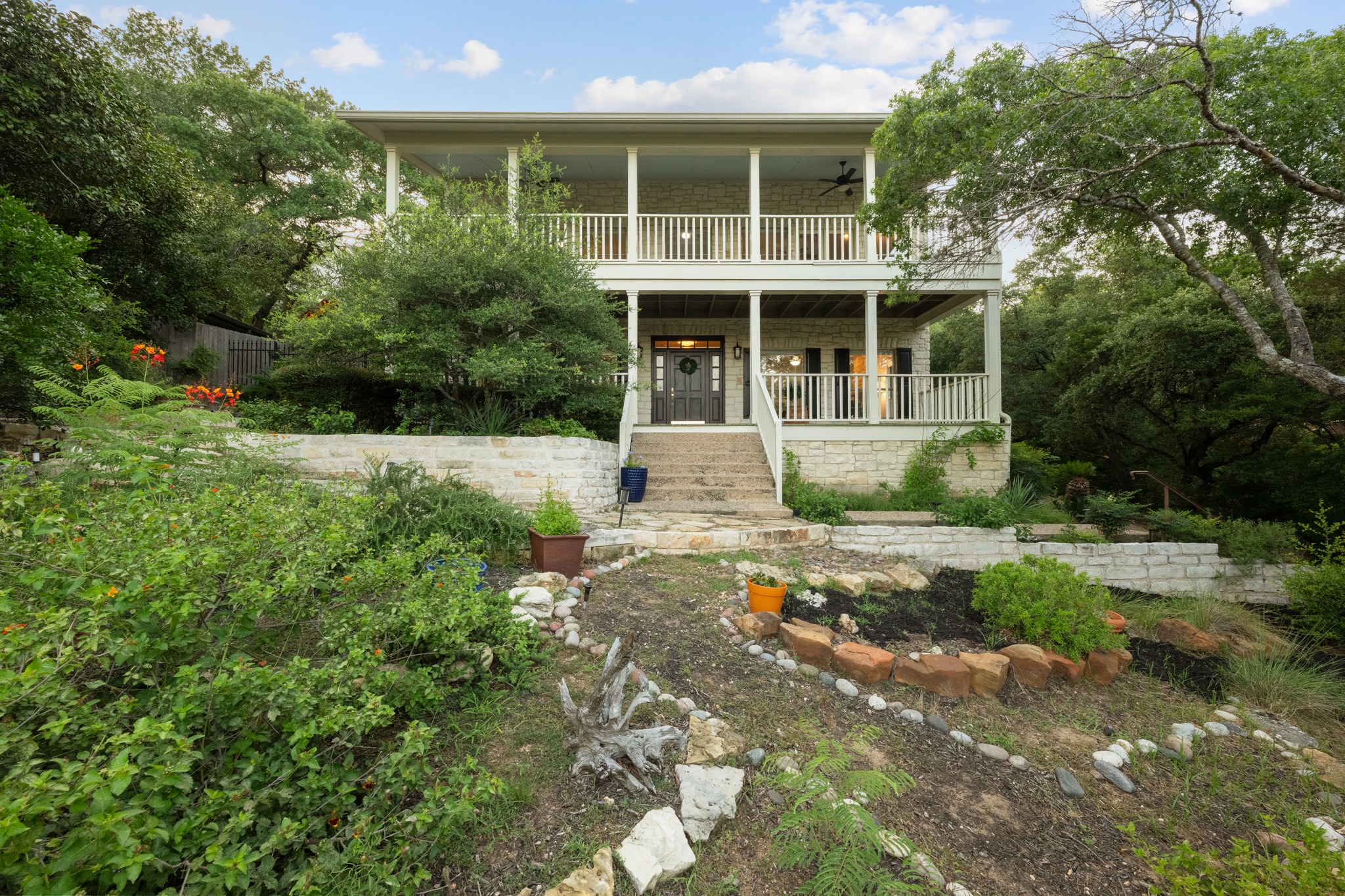 6004 Mt Bonnell Road Austin, TX 78731 - Photo 3 of 24 a front view of a house with a yard and potted plants