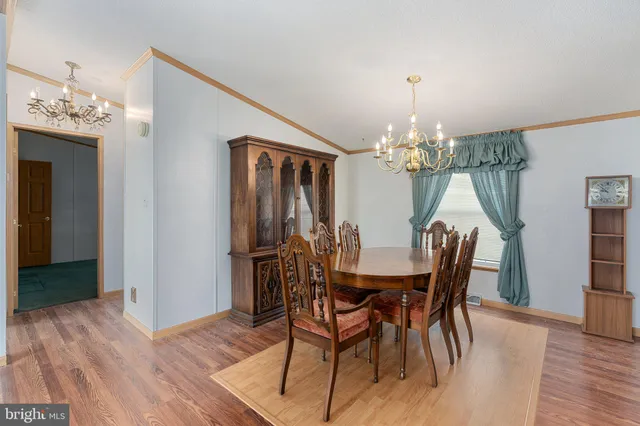 a kitchen with stainless steel appliances granite countertop a sink a stove top oven a refrigerator with wooden floors