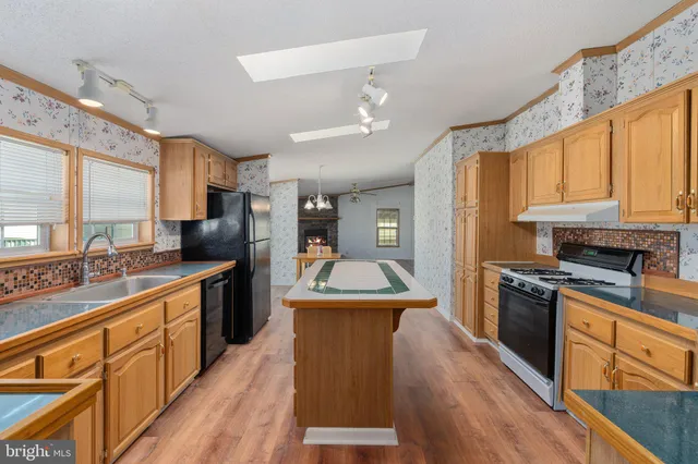 a kitchen with stainless steel appliances granite countertop a sink and a refrigerator