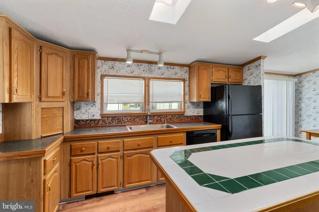 a kitchen that has a lot of cabinets a sink and appliances in it