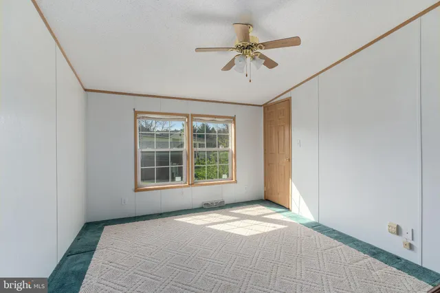 a view of a livingroom with a chandelier fan and a refrigerator