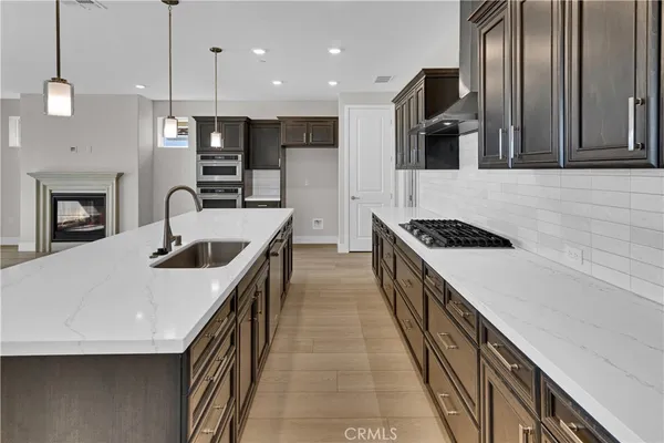 a kitchen with stainless steel appliances granite countertop a sink a stove and a refrigerator